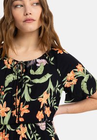 Black floral dress featuring orange and pink flowers with green leaves. Soft fabric, short sleeves, and a tie detail at the neckline.