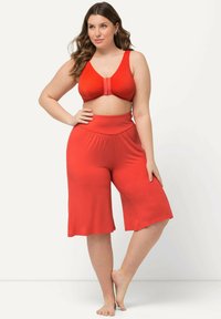 Rode twee-delige outfit met een cropped top met een V-hals en wijdvallende, knielange shorts. Gemaakt van een zachte, elastische stof.