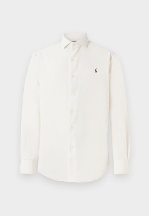 Long-sleeved, white dress shirt made of cotton, featuring a button-down collar and a small navy logo on the chest. Smooth texture, classic fit.
