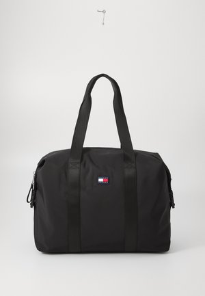 Borsa duffle nera con manici in tessuto doppi, chiusura con zip e una patch decorativa con logo in rosso, bianco e blu sul davanti. Texture liscia.