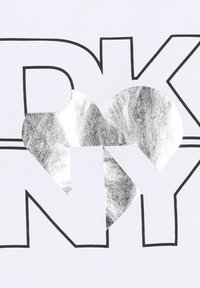 Camiseta blanca con letras negras en negrita "DKNY" y un corazón plateado integrado en el diseño. Textura suave y estampado nítido.