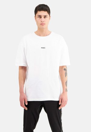 Weiße Baumwoll-T-Shirt mit lockerer Passform, ausgestattet mit einem kleinen schwarzen Logo auf der Brust. Kurze Ärmel und ein runder Halsausschnitt.