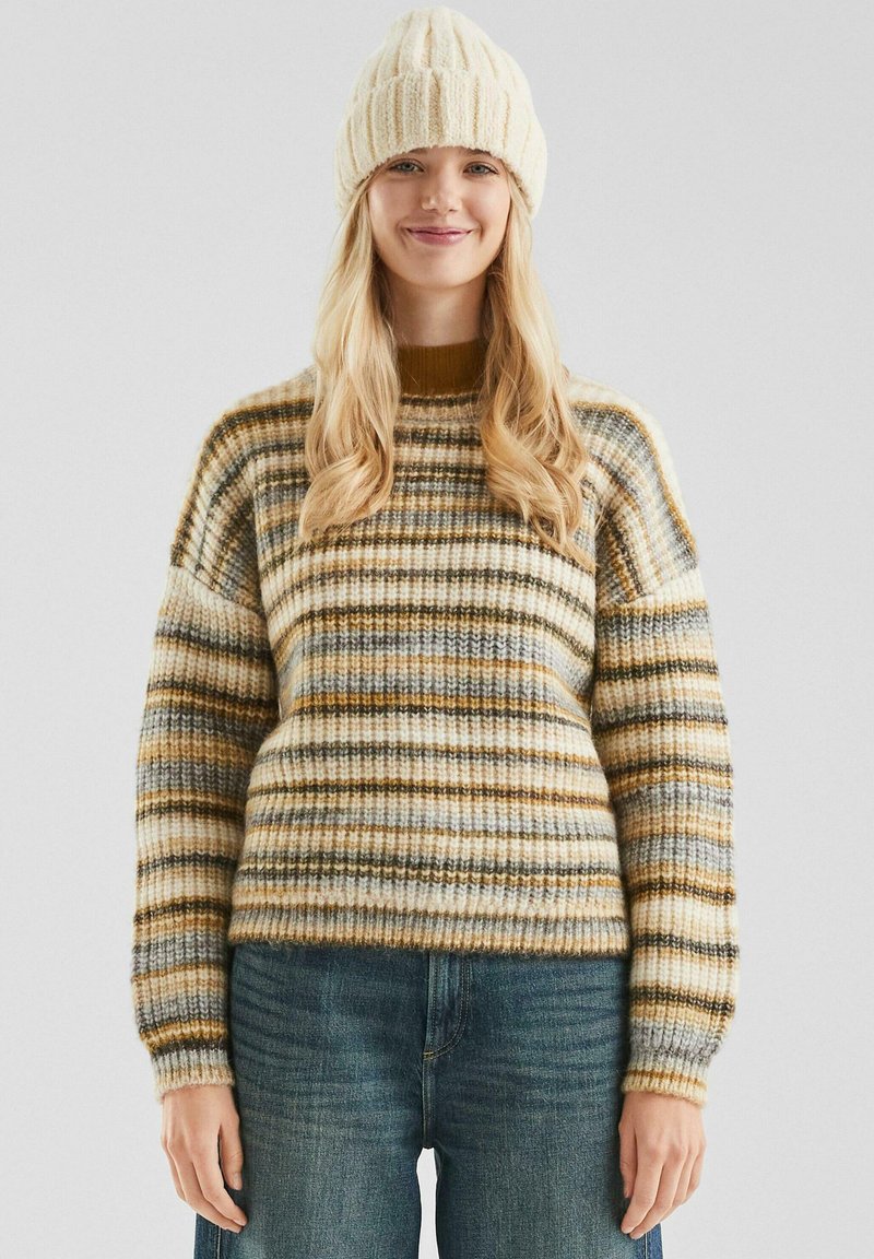 Sweter z dzianiny w poziome paski w kolorach beżowym, żółtym, brązowym i szarym. Ściągacze przy mankietach i u dołu. Dopasowany z dzianinową czapką.
