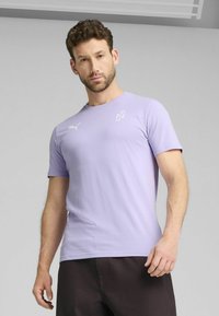 Lys lilla kortærmet T-shirt lavet af bomuld. Har en rund halsudskæring og et lille hvidt Puma-logo på brystet. Glat tekstur.