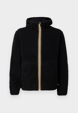 Svart fleece-jakke med hette, med frontglidelås med gule, blå og hvite striper, samt to frontlommer. Mykt, strukturert materiale.