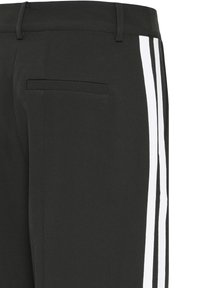 Pantaloni neri con strisce laterali bianche, design su misura con una texture liscia e dettaglio di tasca sul retro.