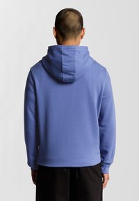 Lyseblå hoodie med dobbelt lag hætte, lange ærmer og en afslappet pasform. Enkel design, blødt stof, ingen synlige mønstre eller hardware.