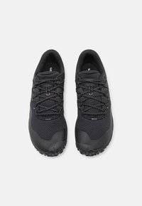 Chaussures de trail running noires avec une tige en mesh texturé, des lacets sécurisés, et une semelle extérieure robuste pour une meilleure adhérence.