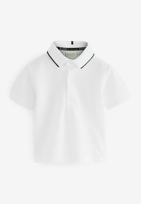 Valkoinen polo-paita, joka on valmistettu teksturoidusta kankaasta. Paitassa on musta reuna kauluksessa, kaksi nappia kaulalla ja lyhyet hihat.