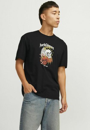 Schwarzes Baumwoll-T-Shirt mit einem Totenschädel-Graphic, das mit Flügeln und Flammen in Rot und Gold verziert ist. Lockerer Schnitt mit kurzen Ärmeln und Design mit Rundhalsausschnitt.