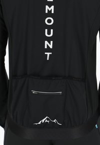 Svart idrottsjacka med en silverlogotyp, en zip-ficka på baksidan och en bergsilhuettdetalj vid fållen.