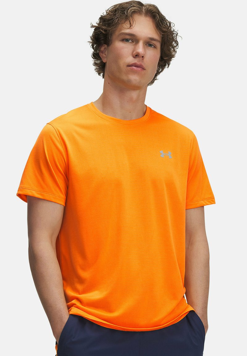 Oranži tugevus t-särk ümarate kaelustega, lühikeste varrukatega ja kergelt soonilise tekstuuriga. Rinnal on väike hõbedane logo.