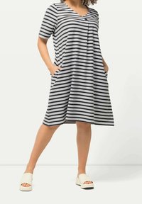 Pasiasta szara i czarna sukienka z dekoltem w serek, krótkimi rękawami i bocznymi kieszeniami. Materiał ma miękką teksturę i luźny krój.