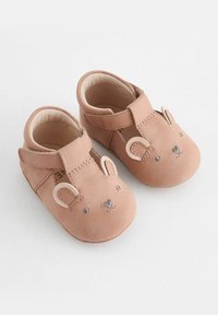 Bløde lyserøde lædersko til babyer med rundede tær, prydet med et bjørneansigt, syede detaljer og strop med velcro for sikker pasform.