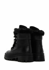Botas de cuero negro con ribete de piel sintética, diseño de cordones, suela de goma gruesa con patrón estriado y acabado ligeramente texturizado.