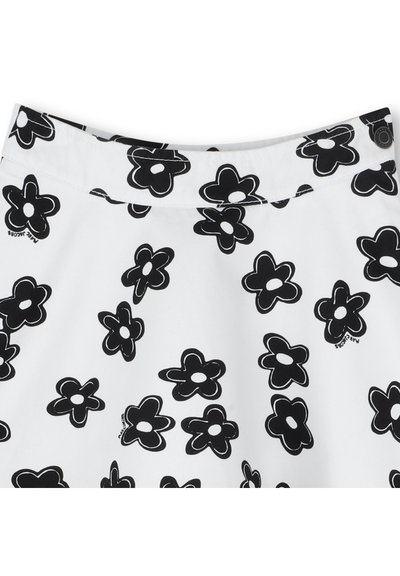 Hvit stoffskjørt med et gjentatt svart blomster mønster. Inkluderer en midjebånd med knappelukking. Kan vaskes i maskin.