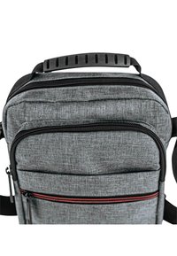 Bolso de hombro de tela gris con herrajes negros, acabado texturizado, dos compartimentos con cremallera y una cremallera roja de acento en el bolsillo delantero.