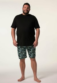 Zwarte korte mouwen t-shirt met een zak, gecombineerd met turquoise bloemmotief shorts, van een lichtgewicht stof en een casual pasvorm.