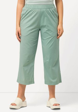 Hellgrüne, verkürzte Hosen aus leichtem Stoff, mit einem elastischen Bund und seitlichen Taschen für zusätzlichen Komfort.