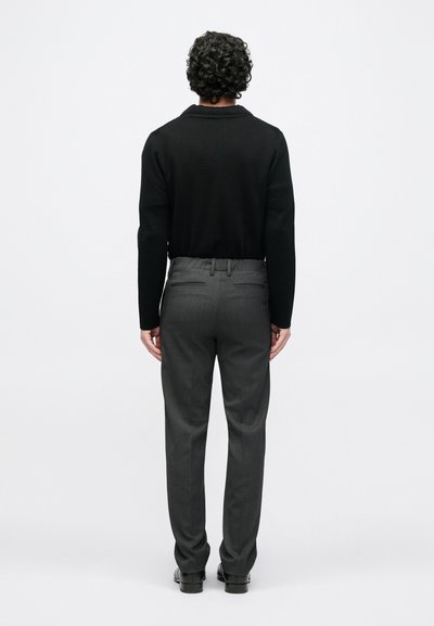 Black long-sleeve sweater and gray tailored trousers, featuring a smooth texture and straight fit. Visible back pockets on the pants.