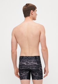 Fekete boxeralsó mintás dizájnnal; elasztikus derékpánt a "BORN BORG" logóval; sima textúra és testhezálló forma.