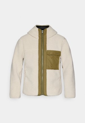 Fleecejacke mit einem cremefarbenen Körper, olivgrünem Reißverschluss vorne und Tasche. Verfügt über einen Kragen, einen Reißverschluss und strukturierten Stoff.