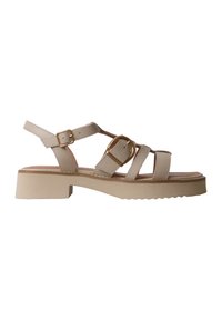Sandale beige à bout ouvert avec un talon bloc bas, trois brides devant et deux boucles réglables dorées à la cheville et sur le dessus du pied.