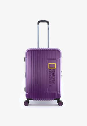 Purple hard-shell suitcase with vertical grooves, retractable handle, and four wheels. Features a yellow logo with "NATIONAL GEOGRAPHIC."
