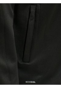 Svart tyg med en slät textur har en dold sidoficka och varumärket "BE ECOOL" tryckt i vitt längst ner.