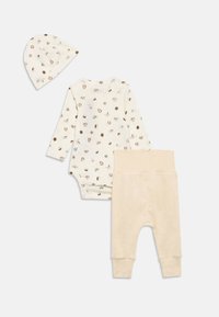 Setul de îmbrăcăminte crem pentru bebeluși include un bodysuit cu mâneci lungi și o șapcă cu imprimeuri de animale, asortate cu pantaloni crem uni, cu manșete la glezne.