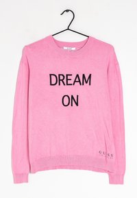 Suéter rosa con cuello redondo que presenta 'DREAM ON' en letras negras. Incluye puños y dobladillo acanalados. Logo de GUESS en la parte inferior izquierda.