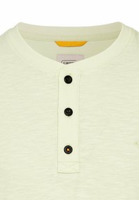 Lys grøn henley skjorte med rund halsudskæring, tre sorte knapper og et tekstureret stof med et lille orange mærke.