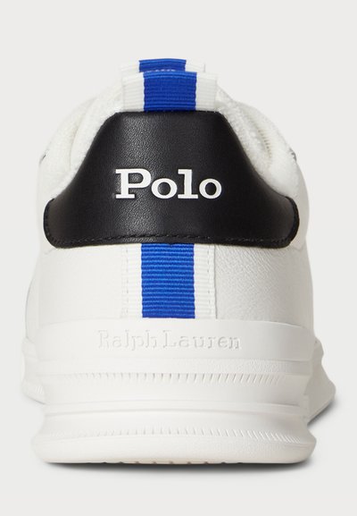 Biele tenisky s čiernym akcentom na päte, s modrými a bielymi pruhmi na zadnej strane. Logo "Polo" zobrazené na päte, textúrovaný materiál.