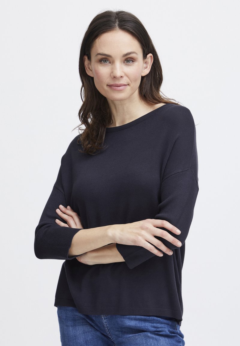 Jūras zila svīteris ar brīvu piegriezumu, apaļu kakla izgriezumu un trīs ceturtdaļu piedurknēm. Izgatavots no mīksta materiāla ar ribotu tekstūru malās.