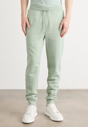Lichtgroene joggingbroek gemaakt van een zachte katoenmix, met een elastische tailleband met trekkoord en zijzakken.