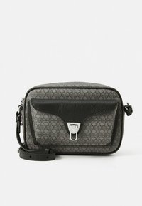 Krūšu soma pelēkā teksturētā audumā ar melnu ādas vāku un sudraba detaļām. Aprīkota ar noņemamu siksnu un rakstainu uzliku.