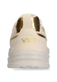 Beige Sneaker mit einem metallisch goldenen Akzent an der Ferse. Verfügt über ein Textil-Obermaterial mit Struktur und eine dicke weiße Sohle. Text "VIN" in Gold.