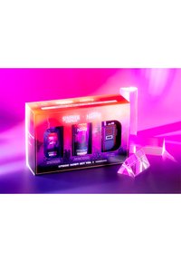 Zestaw do pielęgnacji rąk nawiązujący do Stranger Things, zapakowany w kolorowe pudełko, zawiera trzy produkty: żel do mycia, krem do rąk oraz uchwyt na lotion, z graficznymi akcentami.