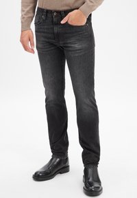 Zwarte denim jeans met een slim fit, voorzien van vijf zakken, lichte slijtage en een contrasterende rode stiksel op de tailleband.