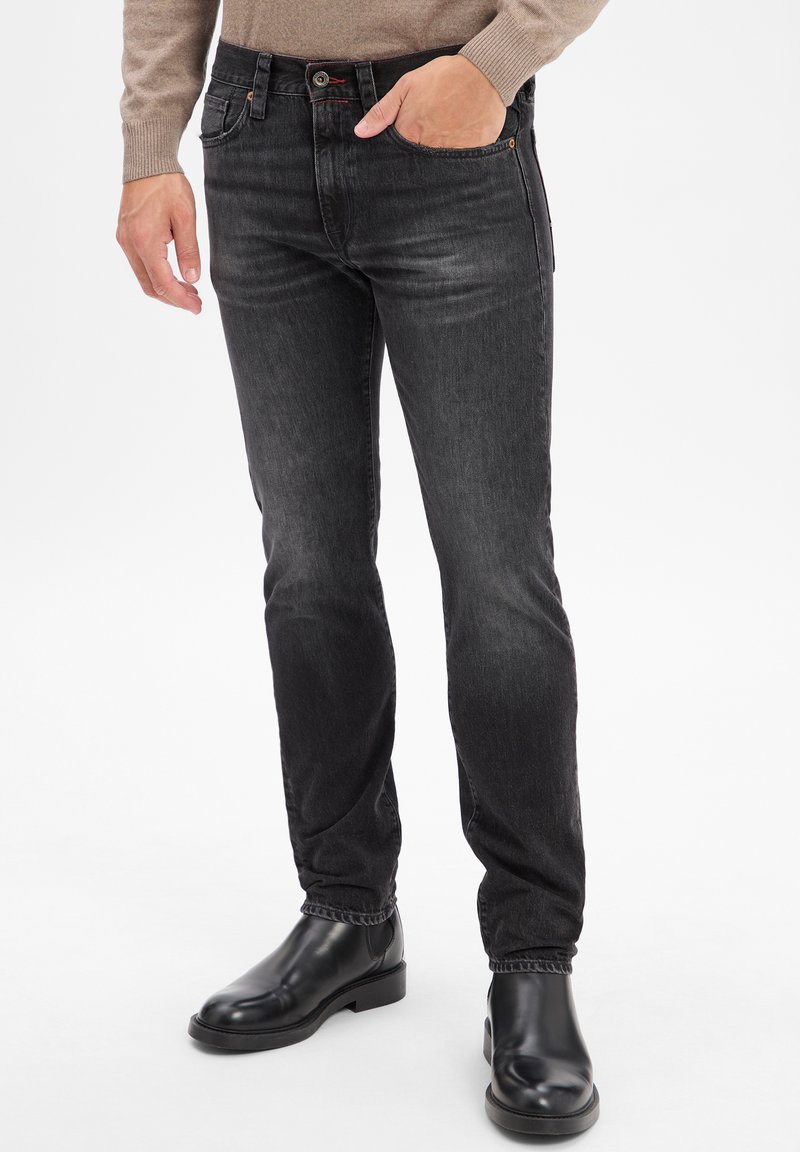 Zwarte denim jeans met een slim fit, voorzien van vijf zakken, lichte slijtage en een contrasterende rode stiksel op de tailleband.