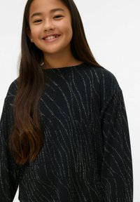 Juoda ilgomis rankovėmis palaidinė su metalinėmis sidabro spalvos linijomis, sukuriančiomis banguotą raštą. Minkšta tekstūra ir laisvas modelis. Apvalus kaklo iškirpimas.