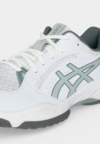 Λευκό και γκρι αθλητικό παπούτσι ASICS με δέσιμο κορδονιών, επάνω μέρος από δίχτυ και συνθετικό υλικό και υφασμένο καουτσούκ στη σόλα.
