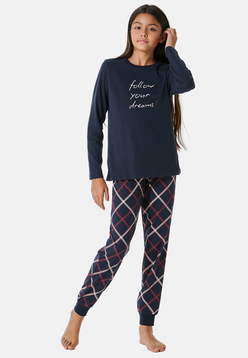 Marinblå långärmad pyjamaströja med vit text "följ dina drömmar!" i kombination med marinblå byxor med ett krämfärgat och rödrutigt mönster.