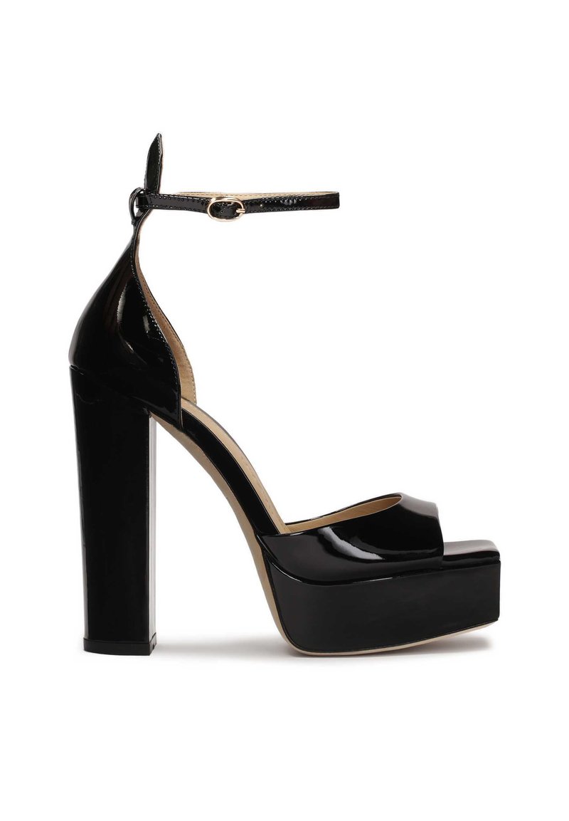 Black patent leather high-heeled platform shoes with a peep-toe design and an ankle strap, featuring a chunky, square heel.
