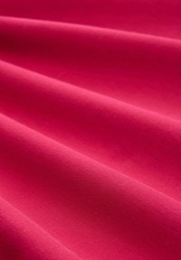 Felroze stof met een gladde textuur, met meerdere zachte plooien die een zacht, vloeiend uiterlijk creëren.