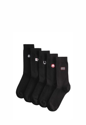 Pięć par czarnych skarpetek, każda z małą, haftowaną ikoną związaną z hazardem: kostki do gry, karty do gry, podkowa, żeton pokerowy oraz automat do gry 777.