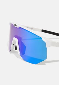 Occhiali da sole sportivi bianchi con una grande lente a sfumatura blu. Presentano un design angolare unico e un evidente nasello bianco.