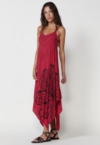 Rotes Skaterkleid mit schwarzem Blumenmuster, taillierter Oberteil, zarte Träger und asymmetrischer, schwingender Saum. Leichter Stoff mit strukturierten Akzenten.