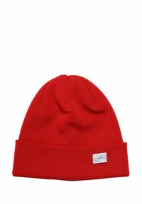 Red knitted beanie hat with a folded cuff and a small branded label on the front, featuring a smooth texture and rounded top.