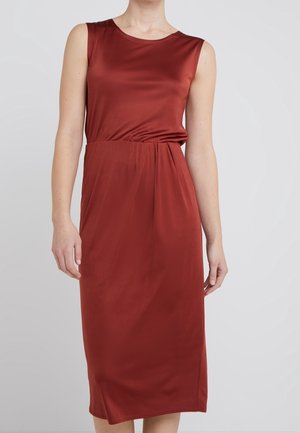 Sleeveless rust-red midi dress with a round neckline and slight gathers at the waist, worn by a person against a plain light background.